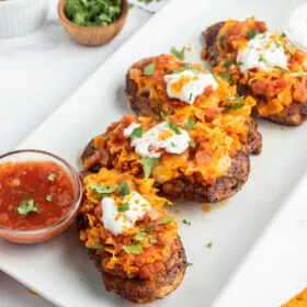 salsa chicken breasts on white platter with bowl of salsa