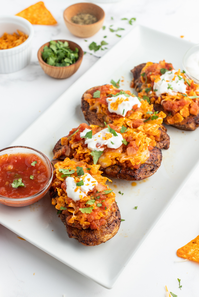 salsa chicken breasts on white platter with bowl of salsa