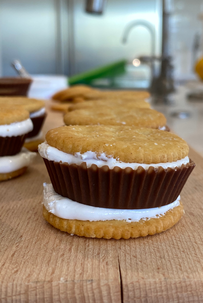 assembly of layered ritz marshmallow cream and reeses in the midddle