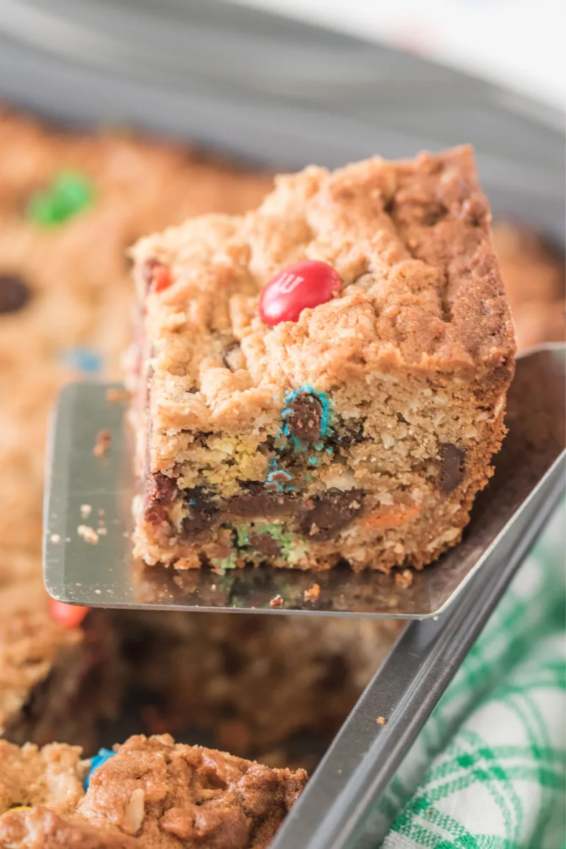 Monster Cookie Bars recipe from RecipeBoy.com #monster #cookie #bars #recipe #RecipeBoy spatula taking out monster cookie bar out of pan