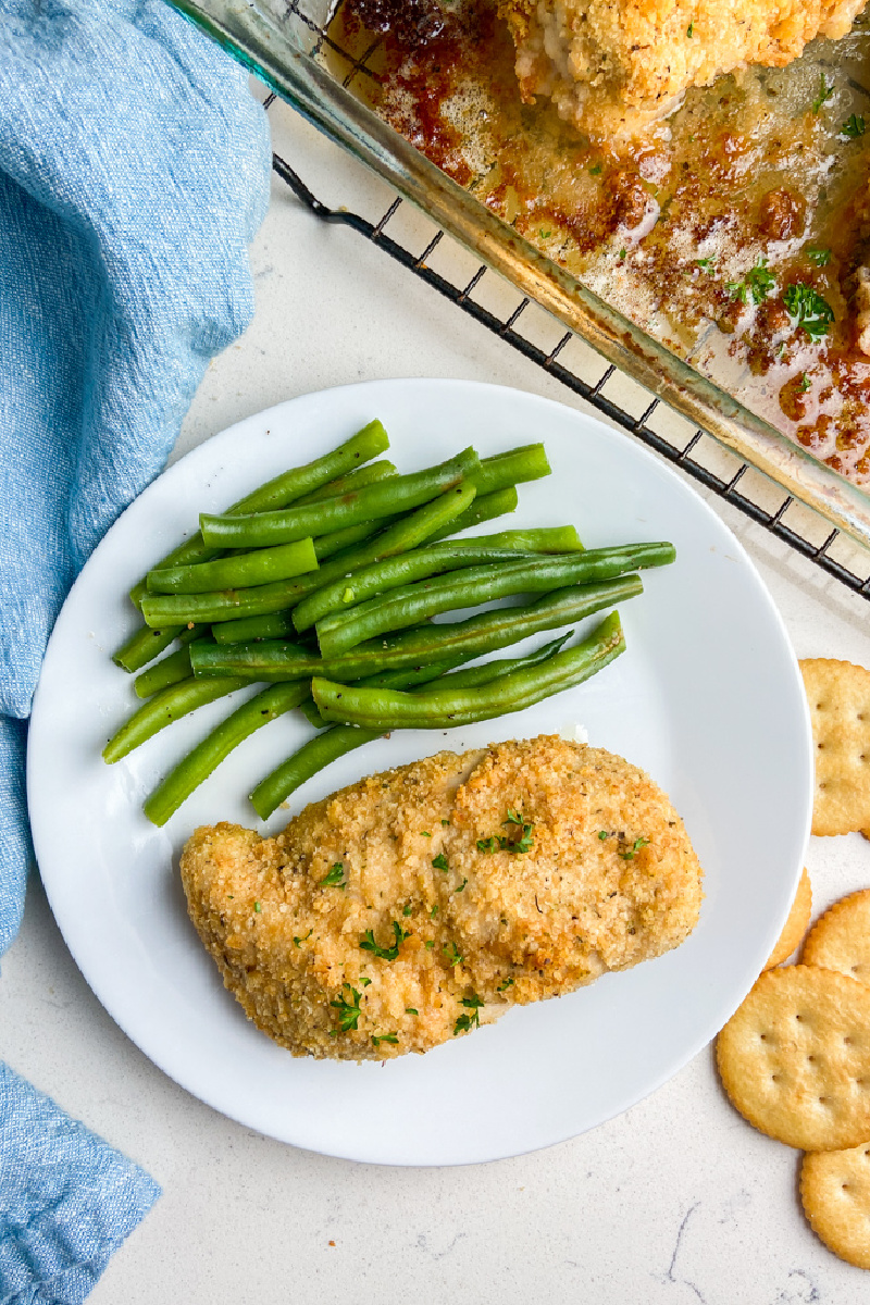 ritz cracker chicken on white plate with green beans