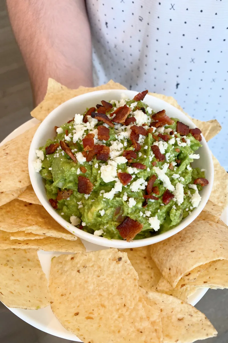 bowl of bacon and cotija cheese guacamole with chips