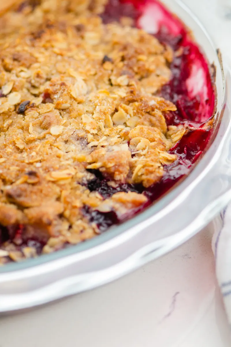 pear and berry crisp in a white casserole dish