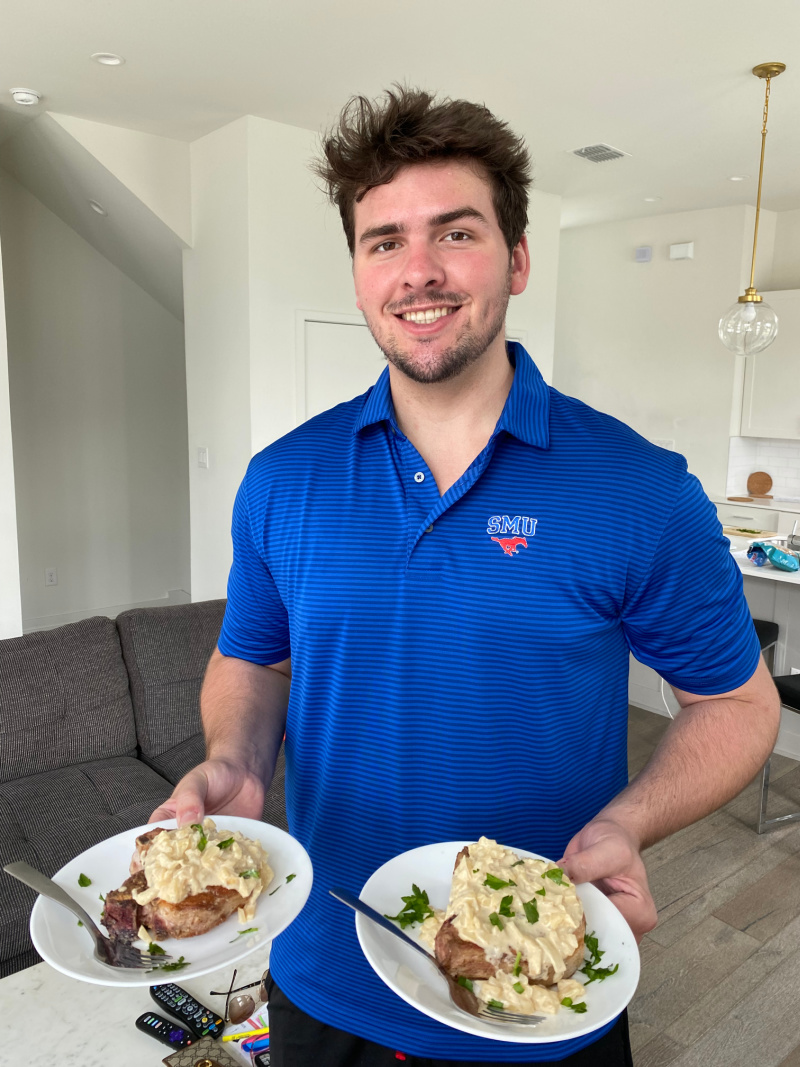 recipeboy serving two plates of pork chops with creamy cinnamon apple sauce