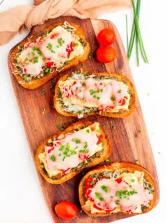 four pieces of breakfast bruschetta on a board