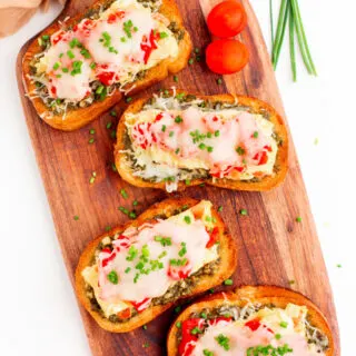 four pieces of breakfast bruschetta on a board