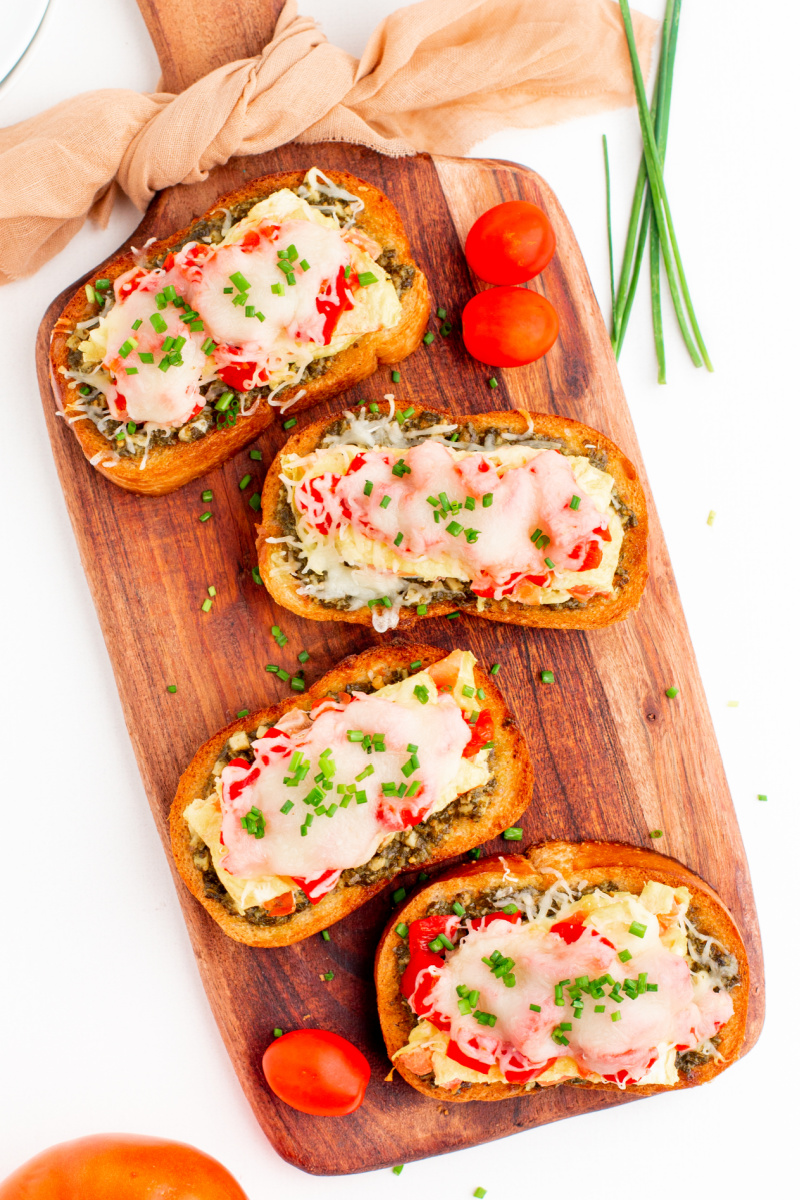 four pieces of breakfast bruschetta on a board