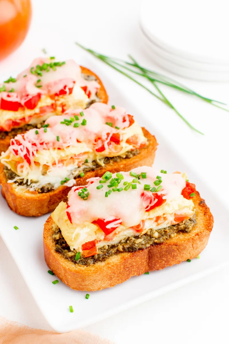 three pieces of breakfast bruschetta on a white platter