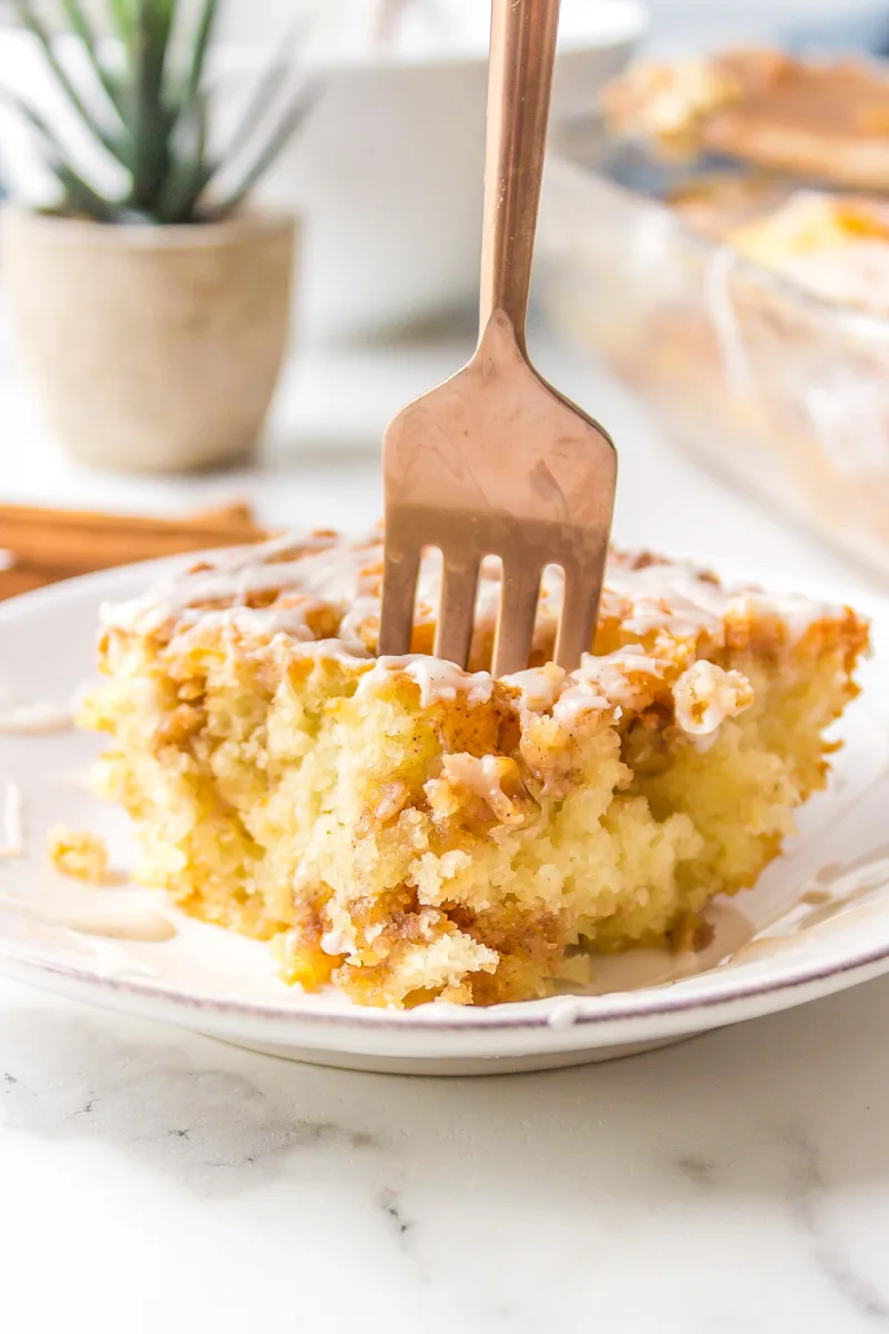 fork inside of slice of cinnamon roll cake