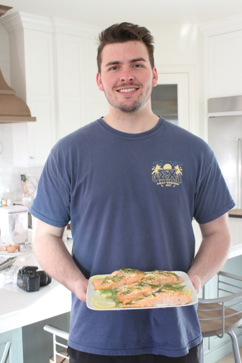 recipeboy holding platter of baked salmon