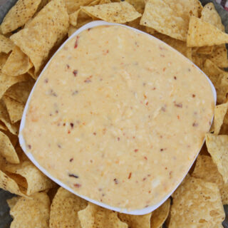 bowl of cheese queso surrounded by chips