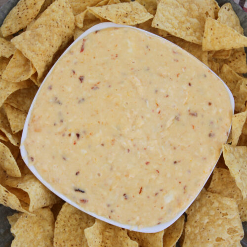 bowl of cheese queso surrounded by chips