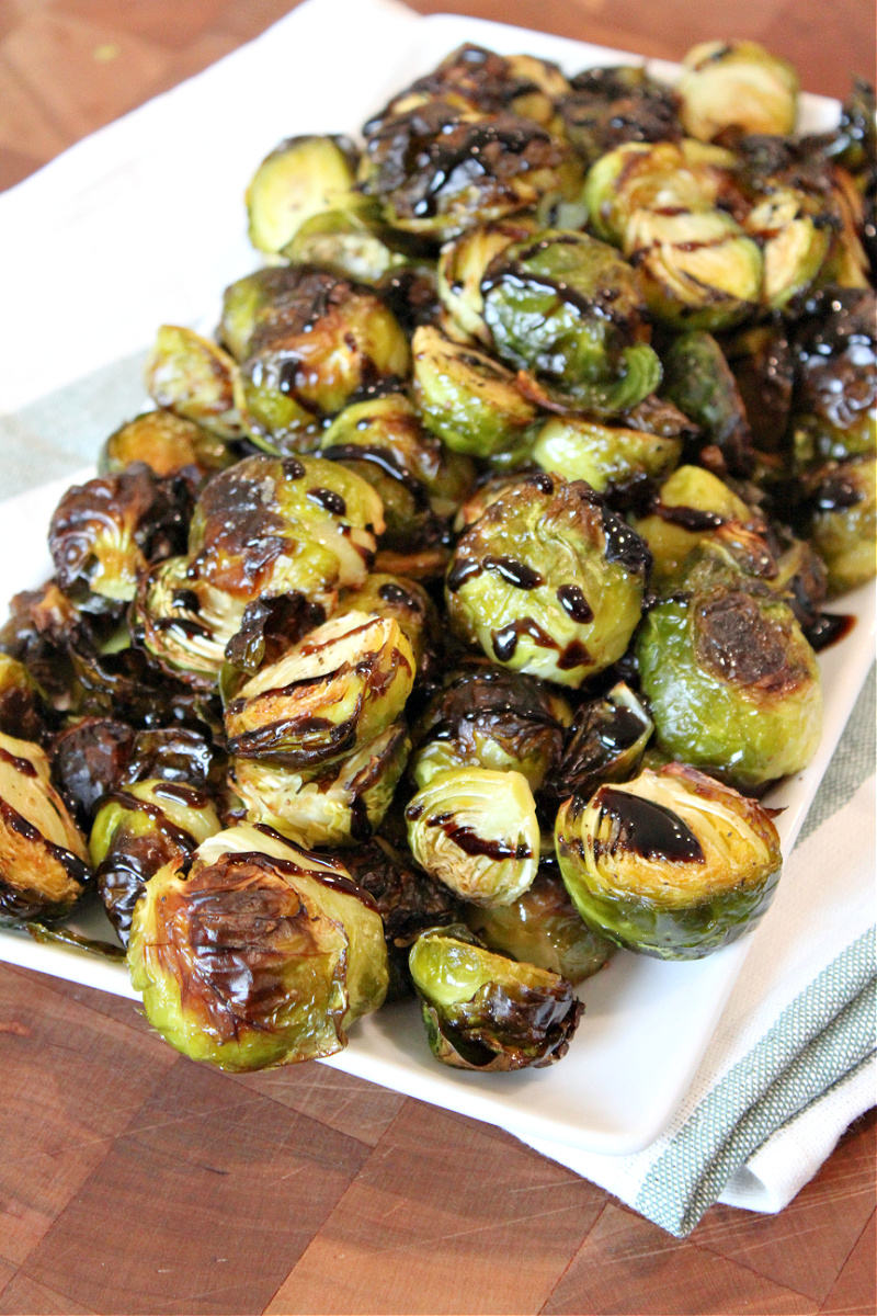 roasted brussels sprouts on a platter with balsamic glaze