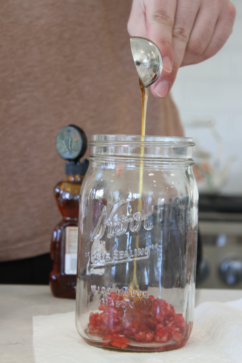 adding ingredients to jar to make salad dressing