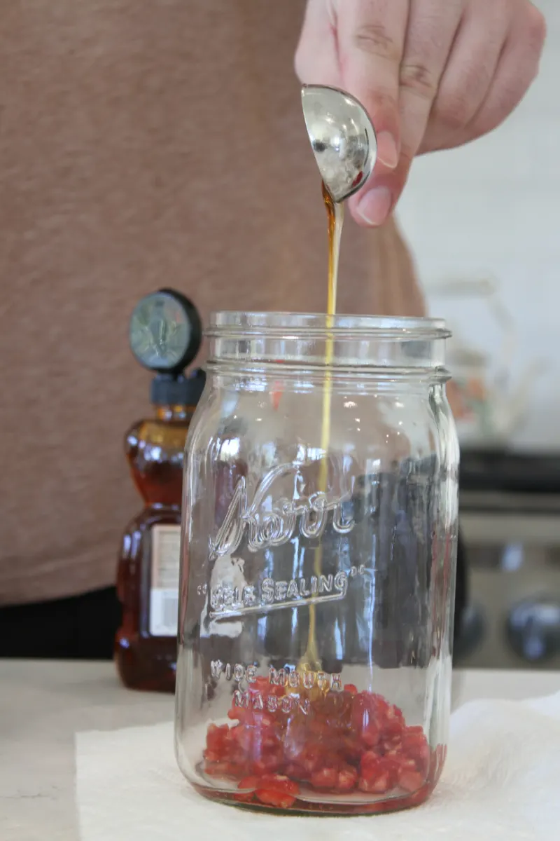 adding ingredients to jar to make salad dressing