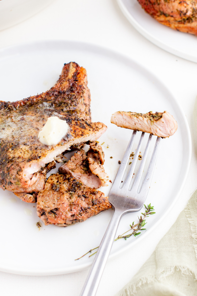 pork chop cut on plate with fork