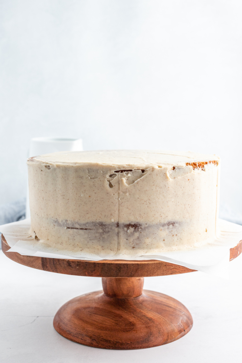 crumb layer of frosting on a layer cake on cake stand