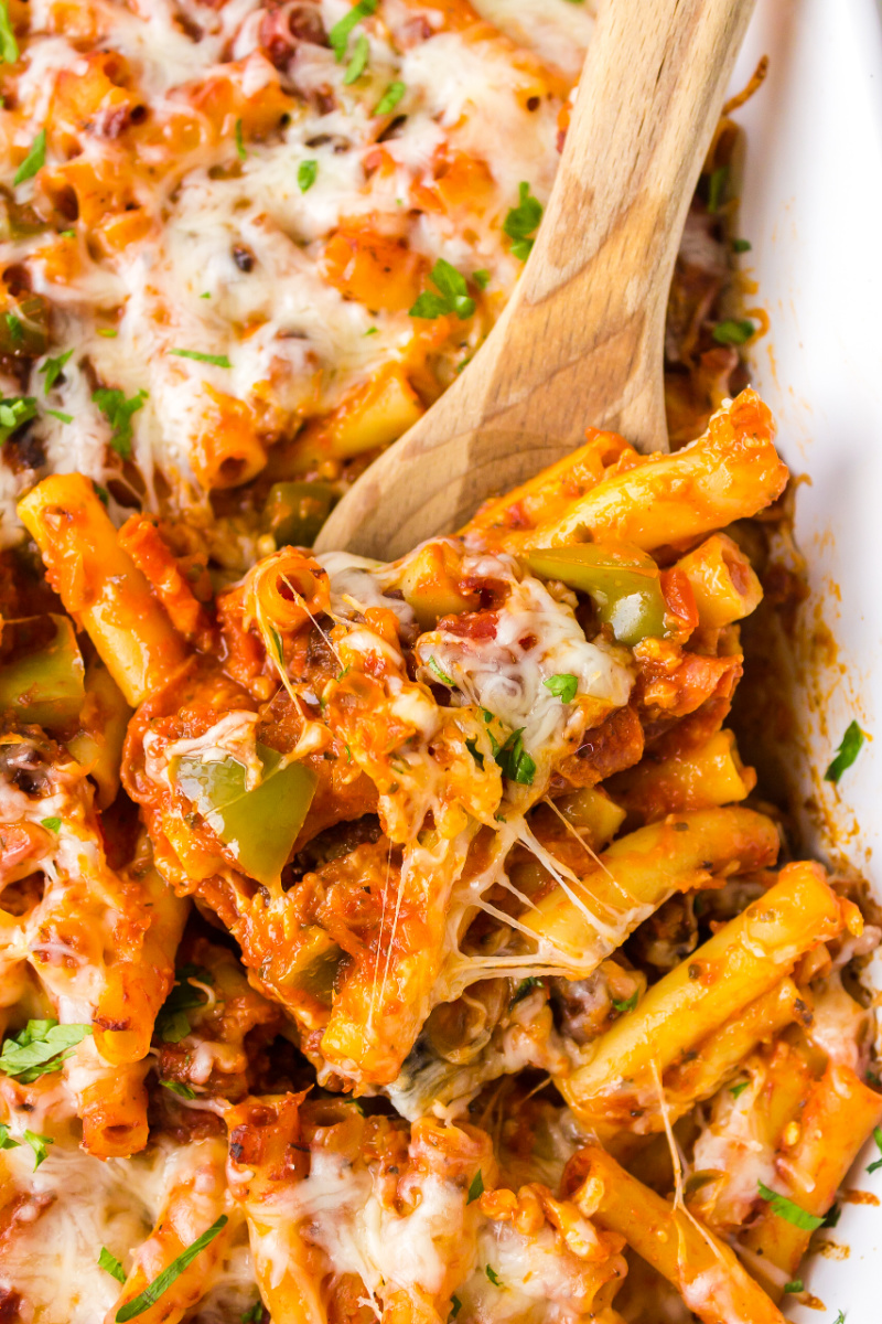 spooning pizza casserole out of dish