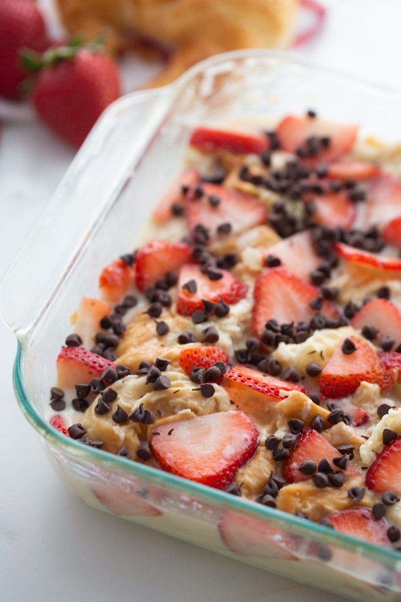 strawberry chocolate chip croissant pudding in a baking dish ready for oven