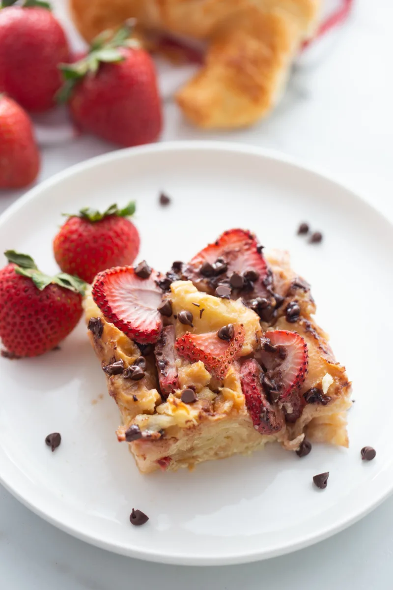 slice of strawberry chocolate chip croissant pudding on a plate
