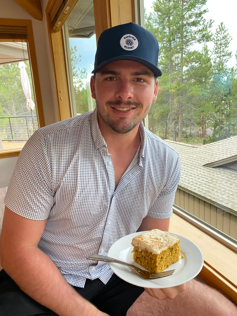 recipeboy holding a plate with a piece of pumpkin sheet cake