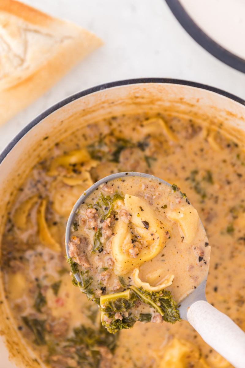 pot of sausage tortellini soup with ladle of soup