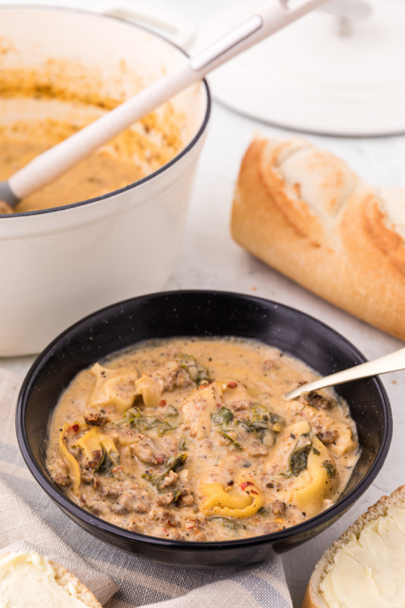 bowl of sausage tortellini soup with spoon