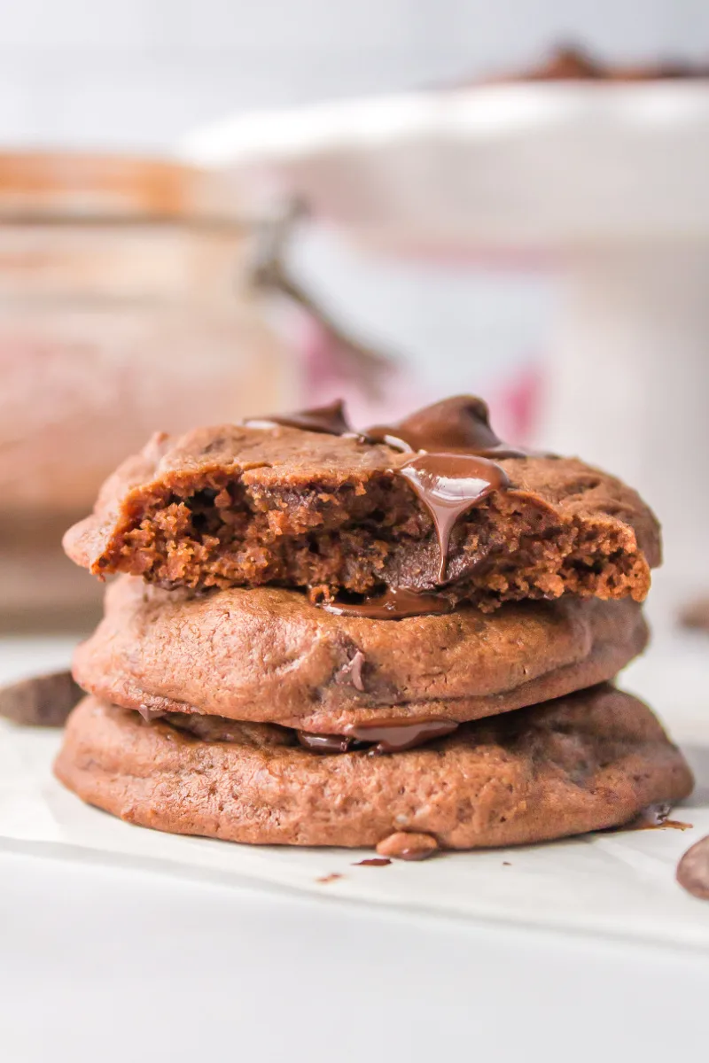 three chocolate cookies stacked- the one on top broken in half