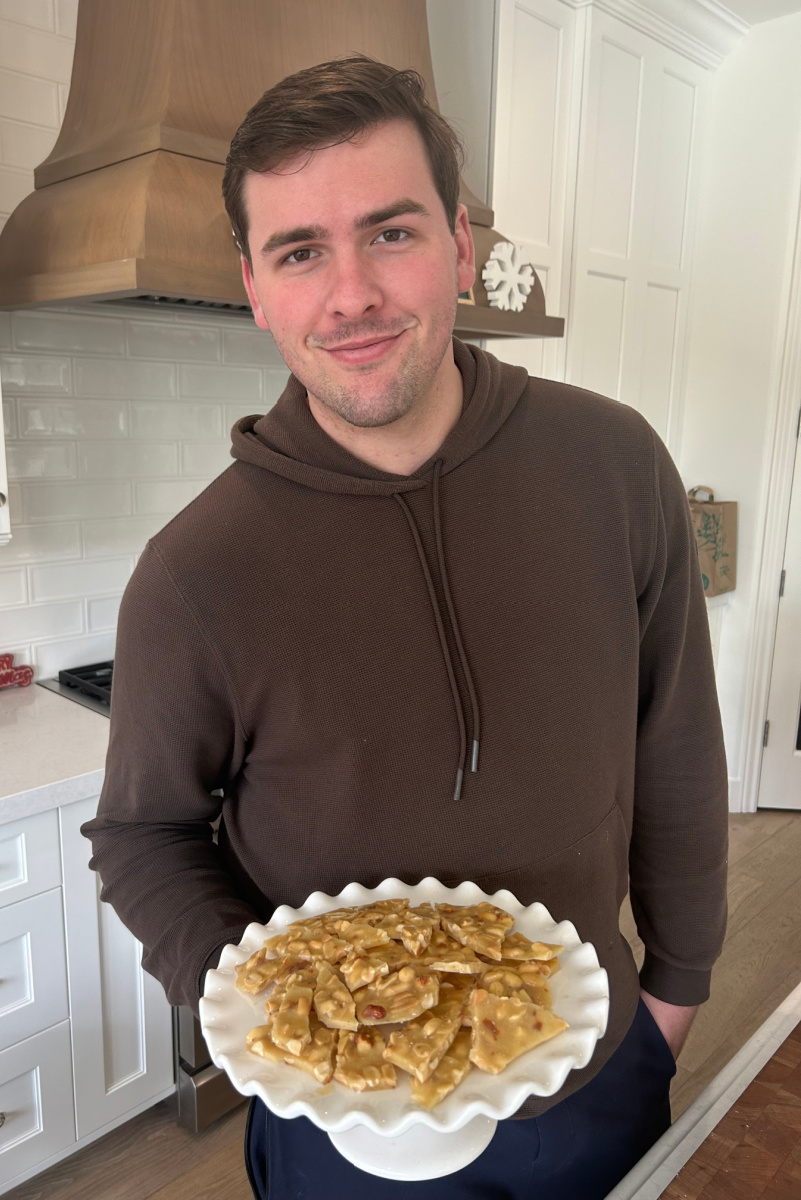 recipeboy holding tray of peanut brittle