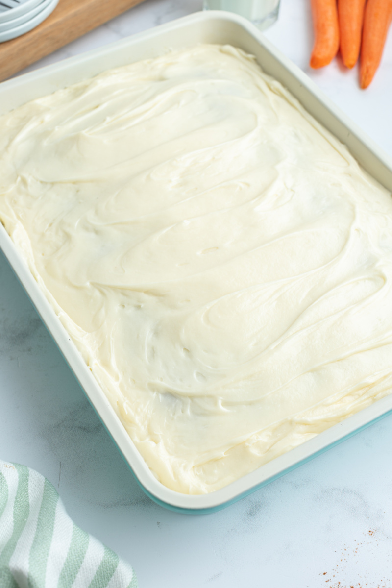 carrot cake in pan with cream cheese frosting