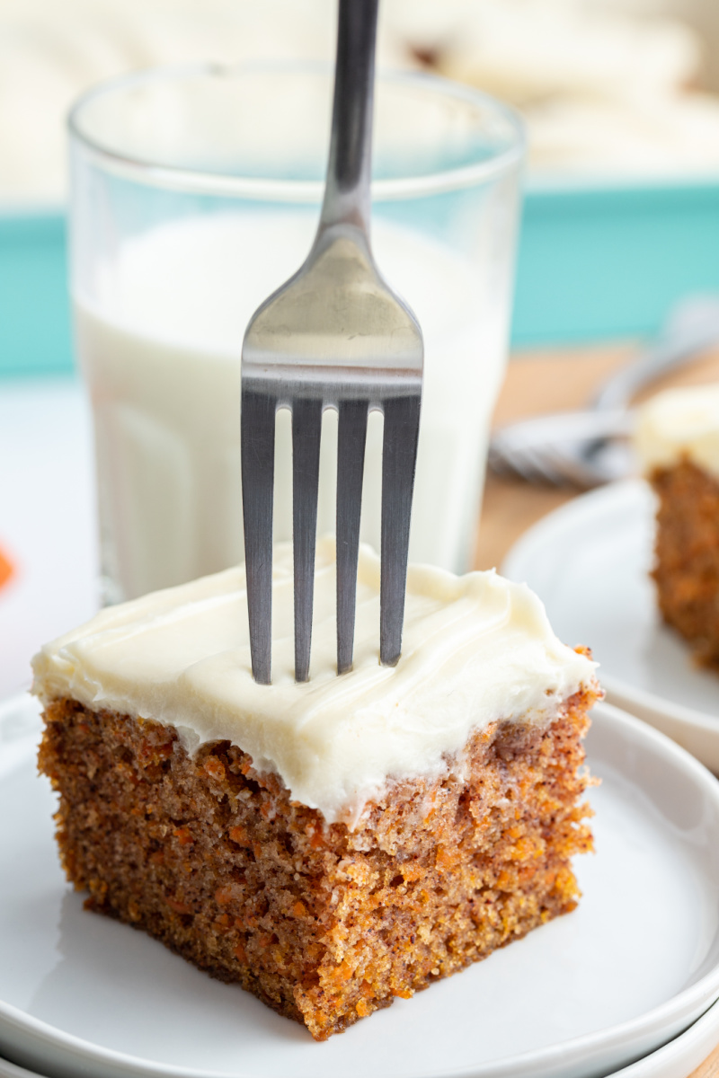 fork cutting into slice of carrot cake