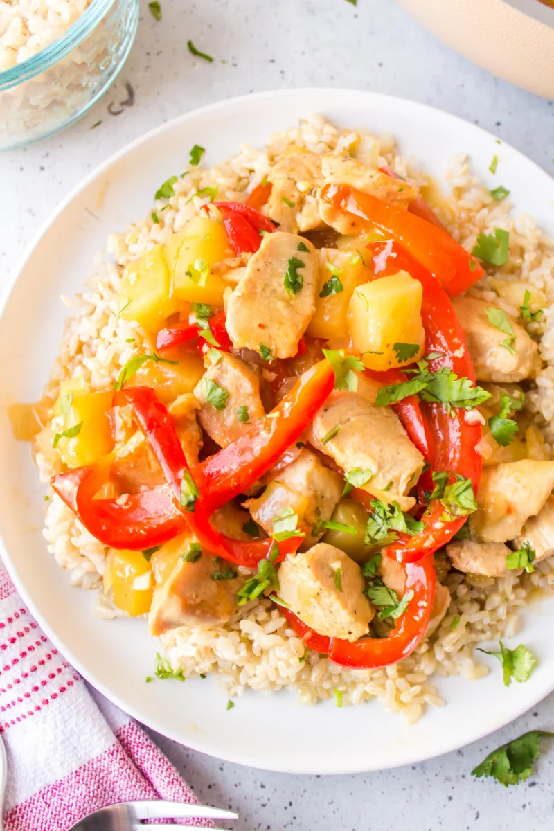 pineapple ginger chicken stir fry over rice on a plate