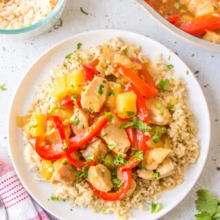 pineapple ginger chicken stir fry over rice on plate