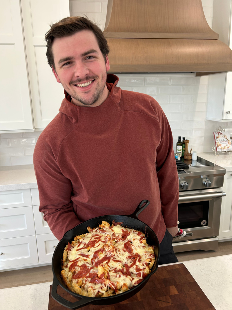 recipeboy holding pan of pizza fries