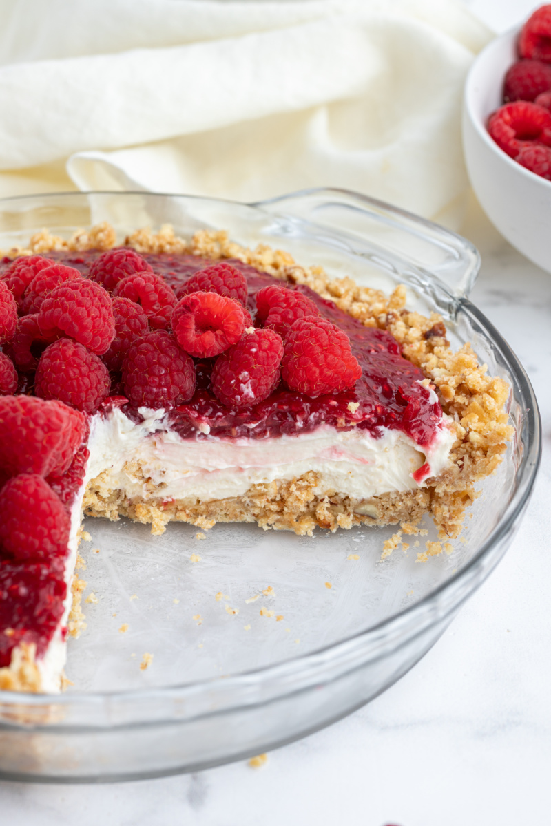 raspberry cream pie with big slice taken out of it