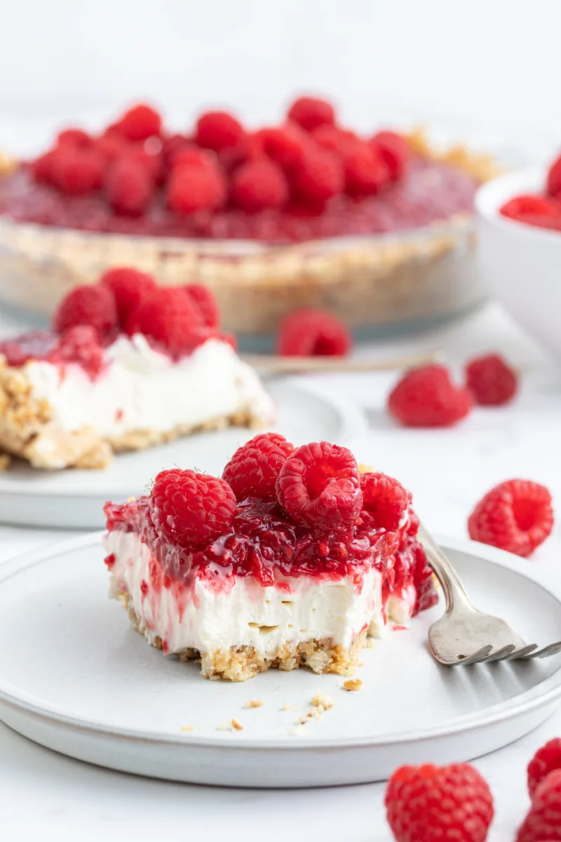 raspberry cream pie on plate with bite taken out of it