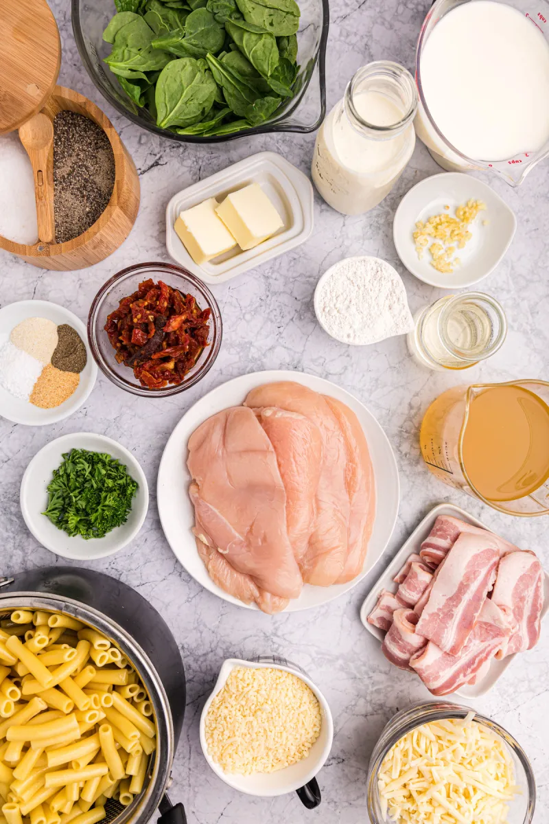 ingredients displayed for making creamy tuscan chicken pasta bake