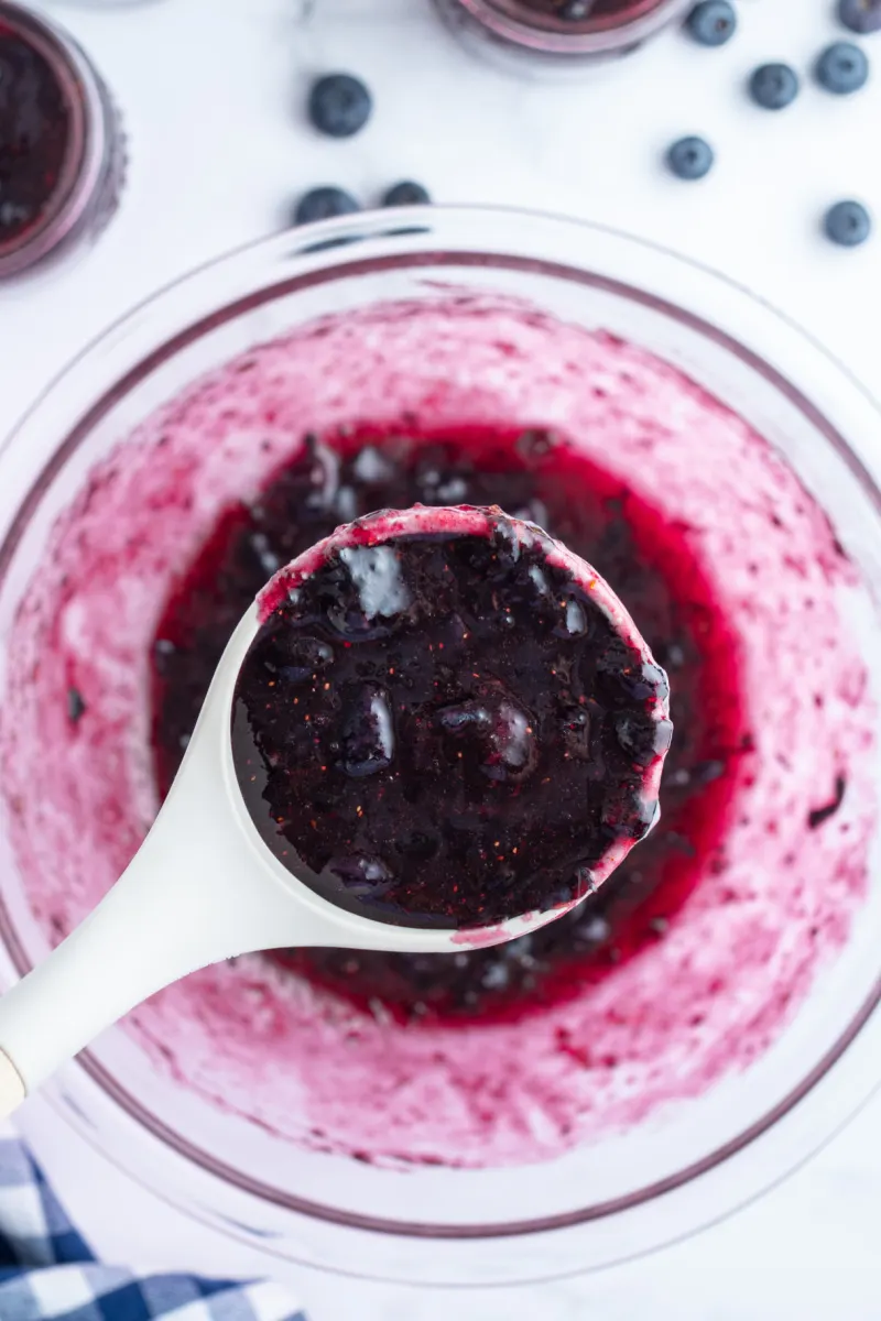 spoonful of blueberry jam over bowl