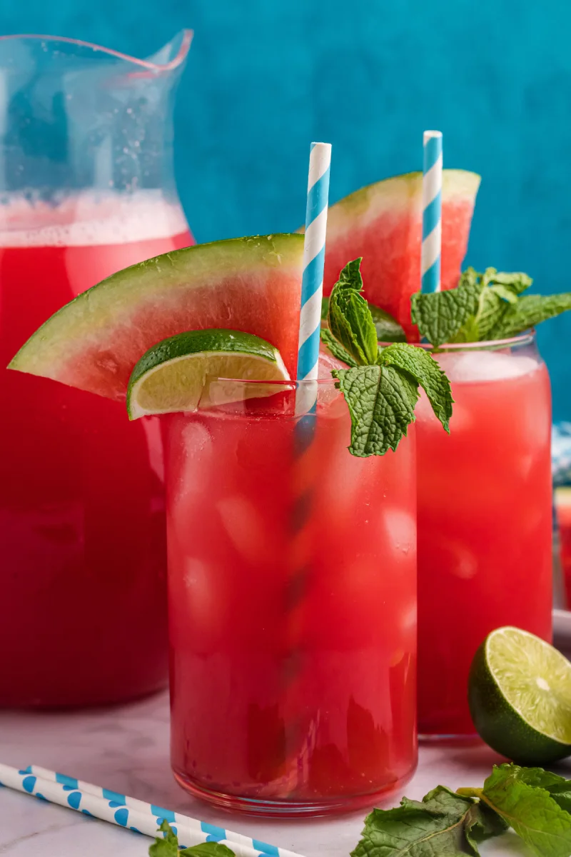 glasses of watermelon agua fresca with straws and mint garnish