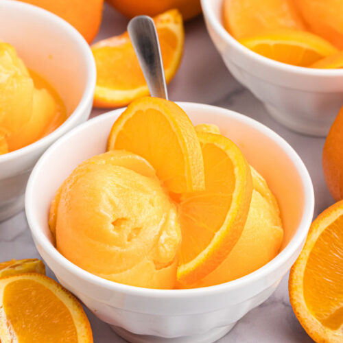 orange sherbet in bowl with orange slices