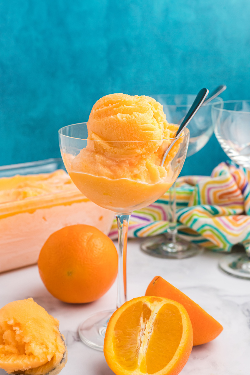 scoop of orange sherbet in glass dish