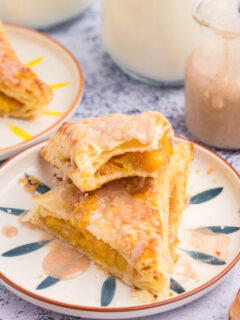 two peach turnovers stacked on plate and sliced open