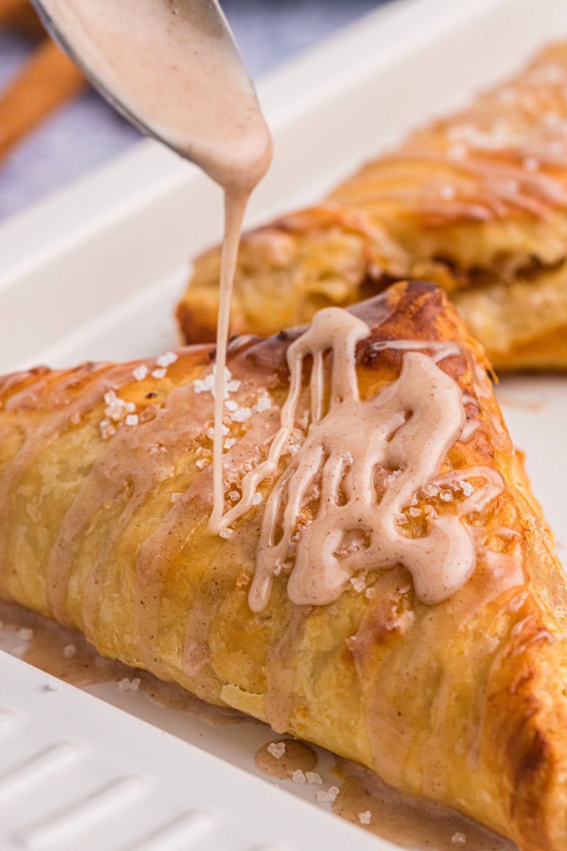 drizzling glaze onto peach turnover