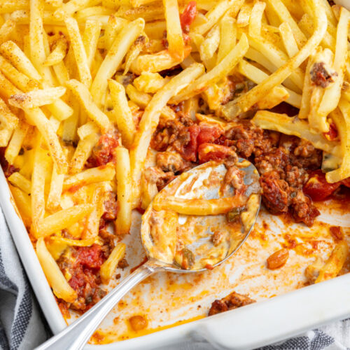 cheeseburger and fries casserole with serving spooned out of it