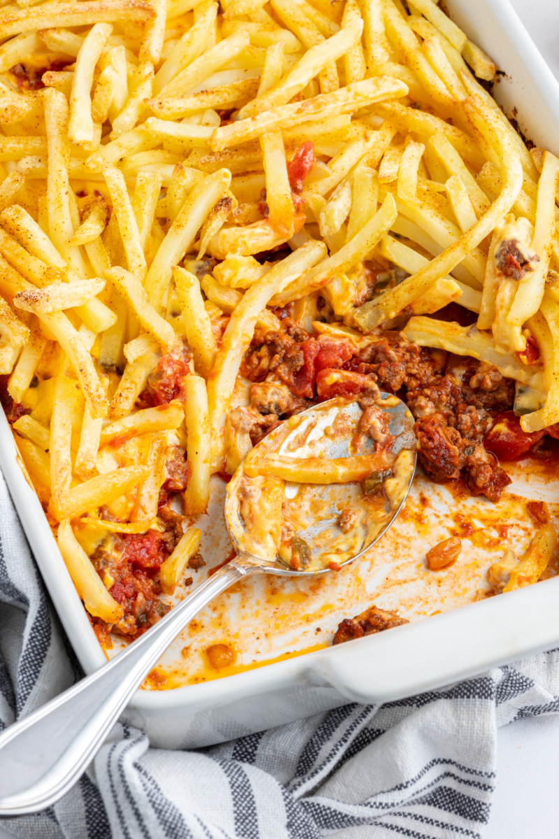 cheeseburger and fries casserole with serving spooned out of it