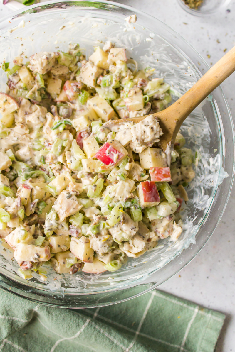 chicken apple salad in a bowl with a wooden spoon