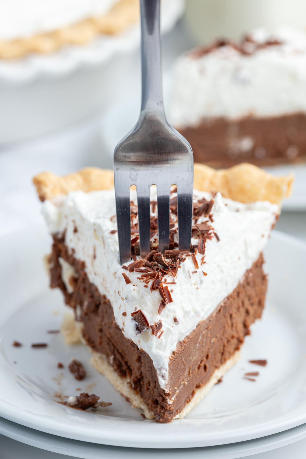 slice of french silk pie o nplate with fork sticking out the top