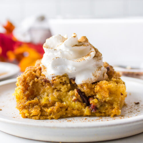 slice of pumpkin dump cake with whipped cream on top