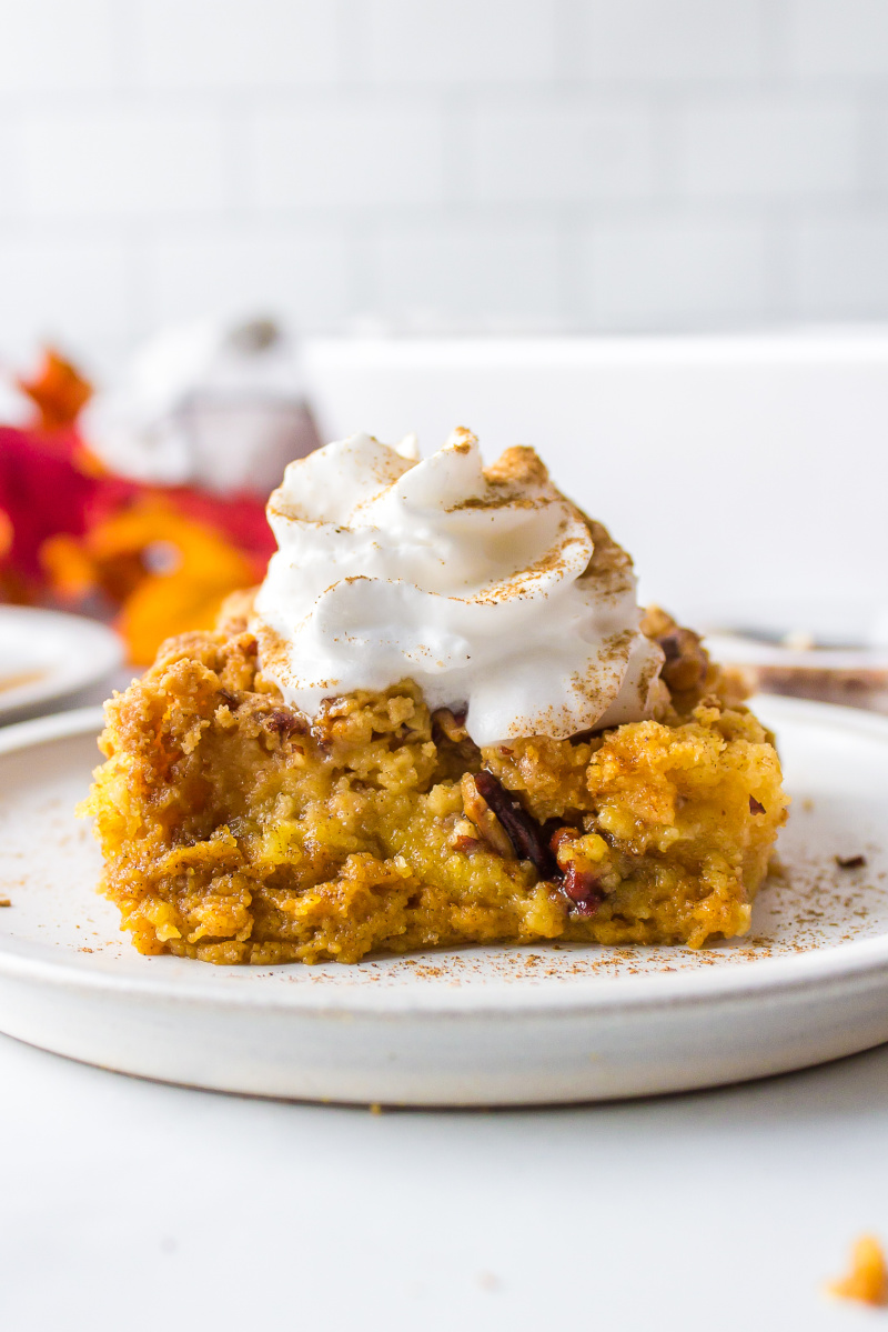 slice of pumpkin dump cake with whipped cream on top