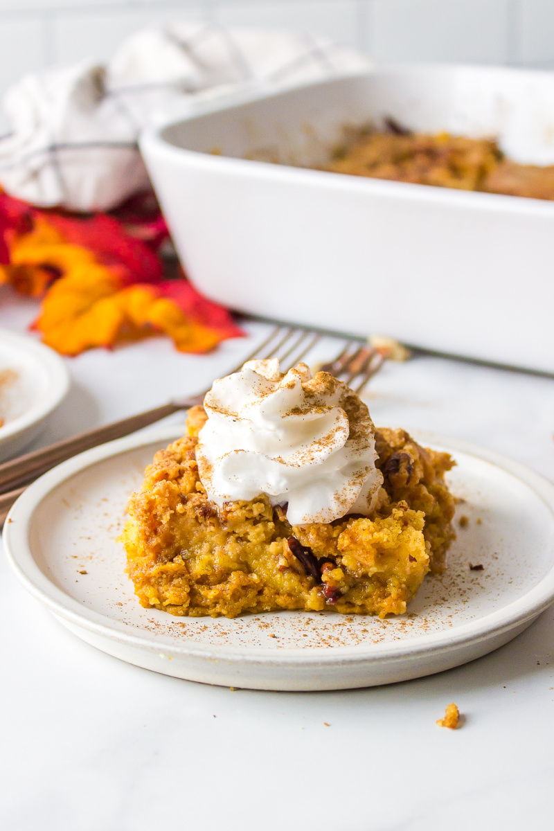 slice of pumpkin dump cake on plate with whipped cream